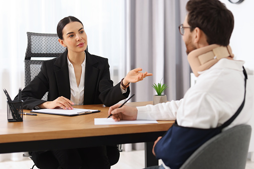 Injured man signing document in lawyer's office