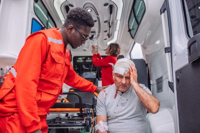 In-ambulance care for an injured older man with a bandaged head in Apollo Beach, FL
