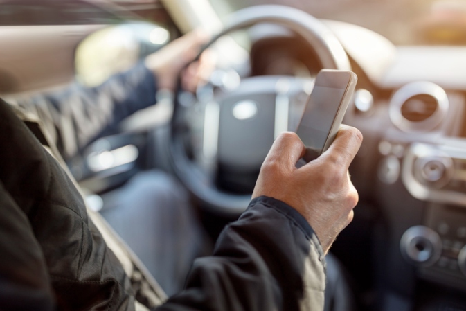 A driver holding a smartphone is distracted while driving in Apollo Beach, FL
